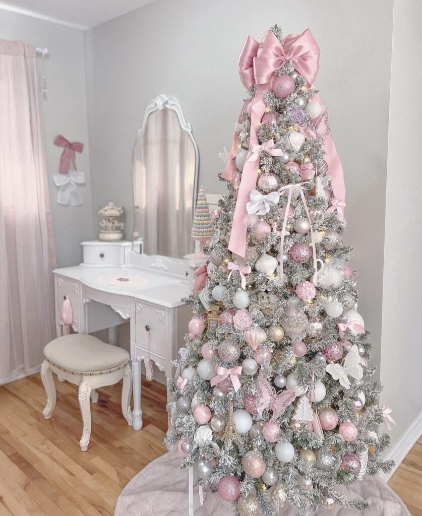 A pink and silver Christmas tree with butterflies and ribbon bows.