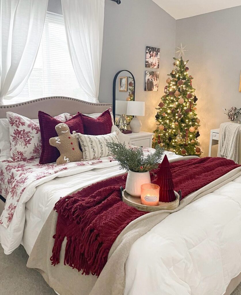 A bed with a Christmas tree next to it and a gingerbread man pillow.