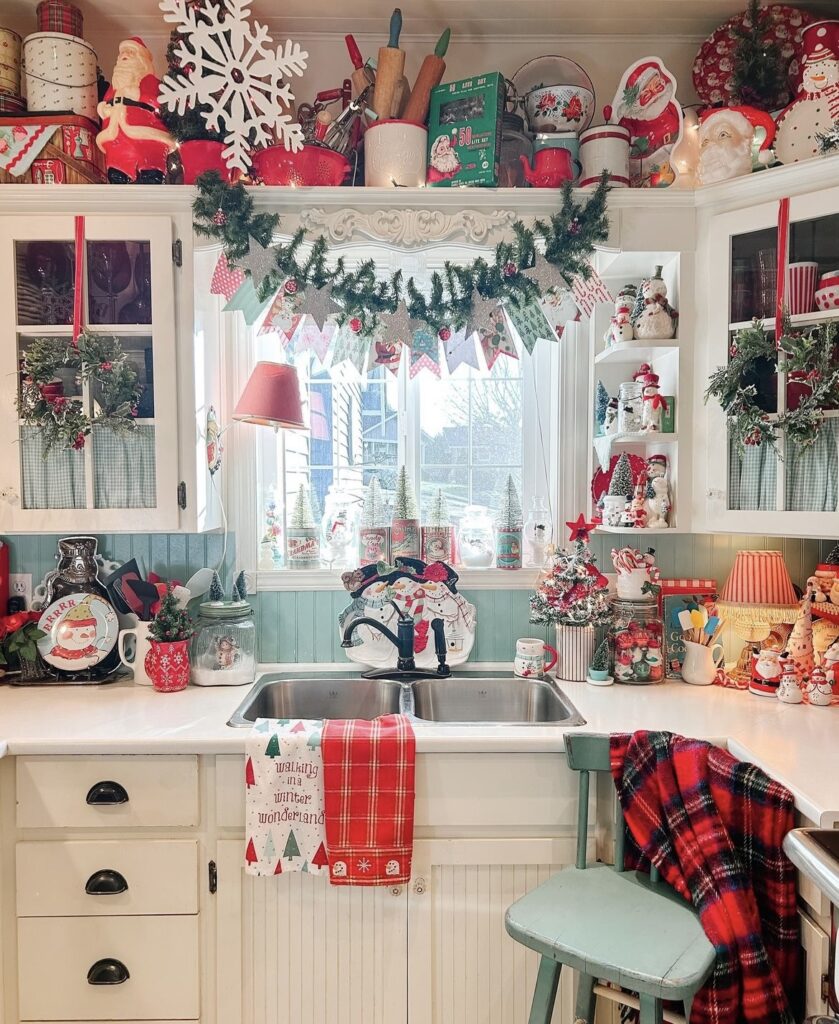 A top of kitchen cabinet filled with Christmas figurines and wooden signs.