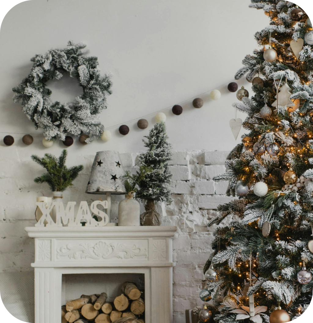 A white mantel with a "Xmas" wooden sign next to a Christmas tree.