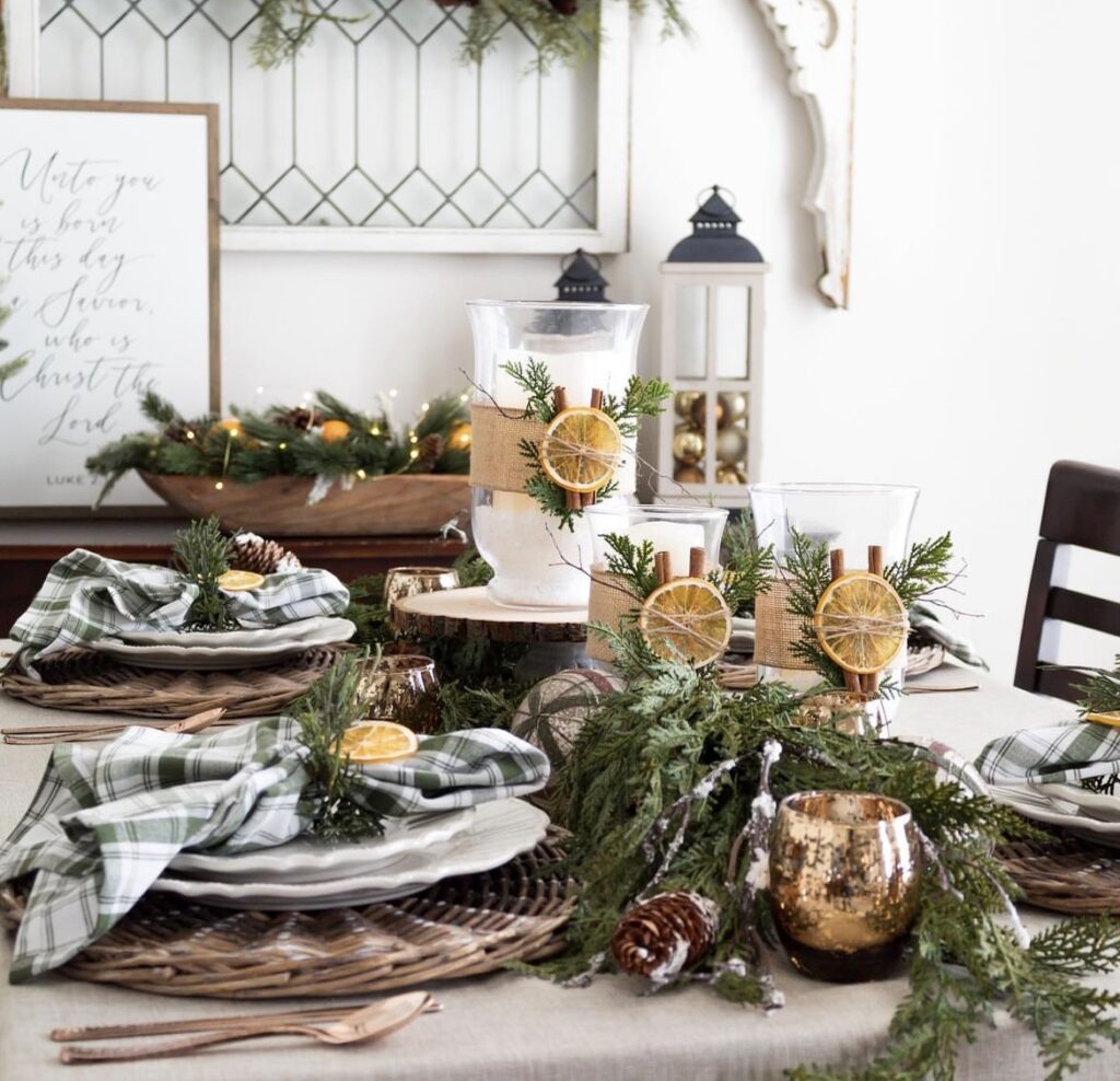 A Christmas centerpiece with pine branches and orange dried slices.