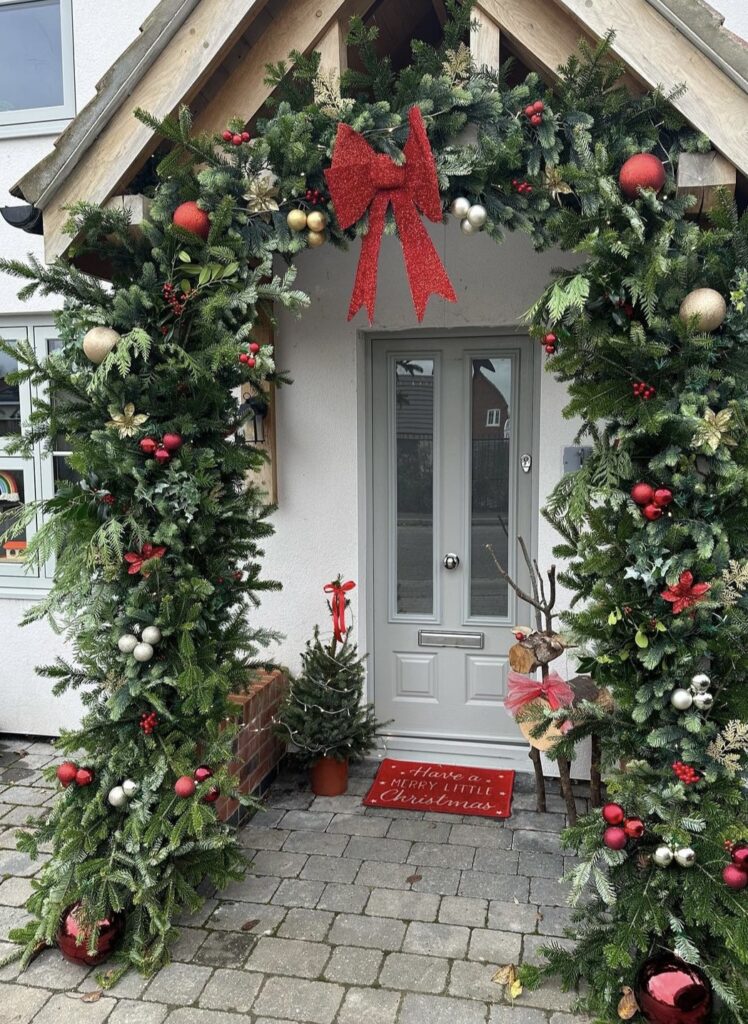 A Christmas porch with ribbon bows and Christmas balls.