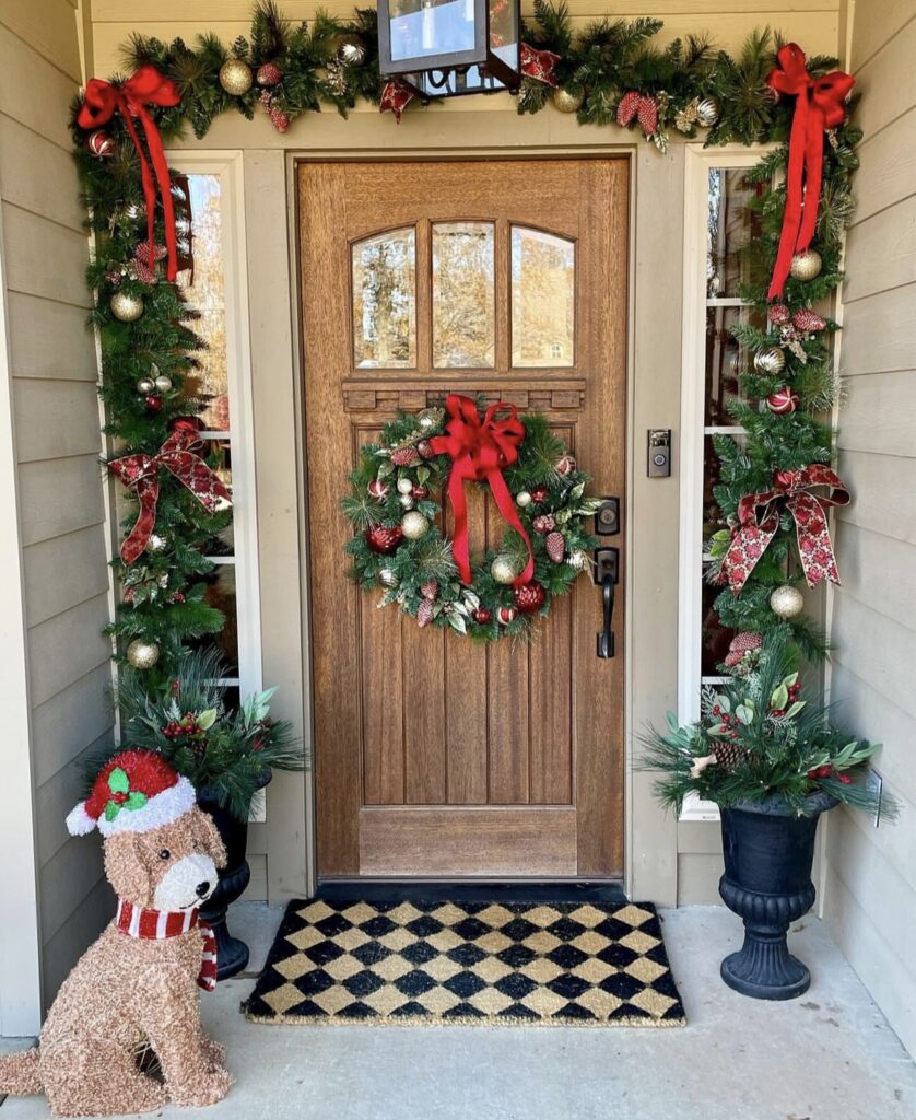 A pine branch garland with red ribbon bows and Christmas balls.