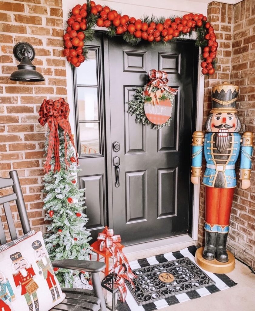 A Christmas porch with a large nutcracker.