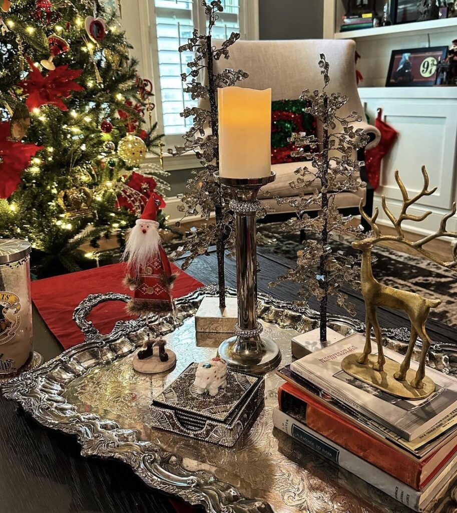 A gold deer with silver metal pine trees on an antique tray.