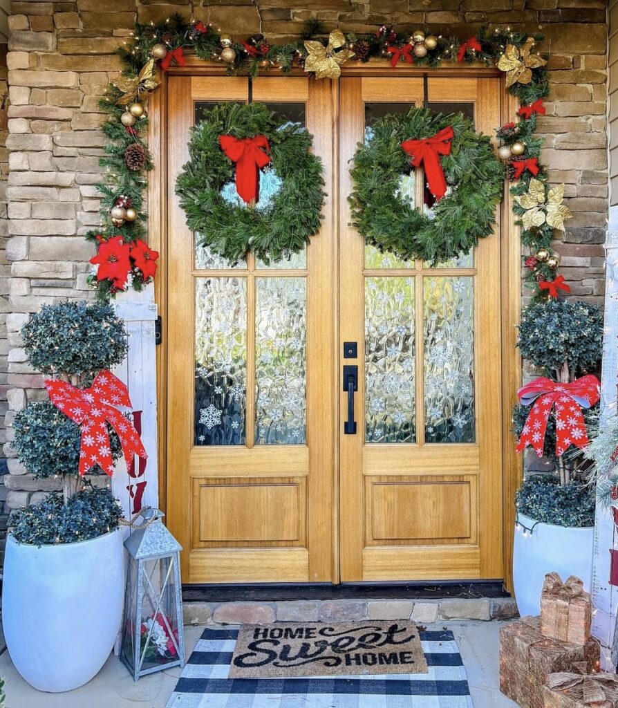 A Christmas porch with red ribbon bows and pine branches.