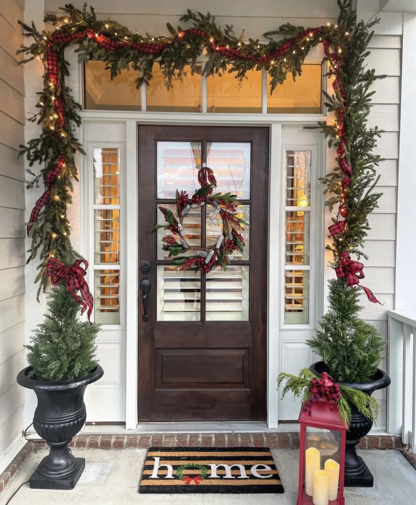 A pine branch garland with string lights and buffalo plaid ribbon.