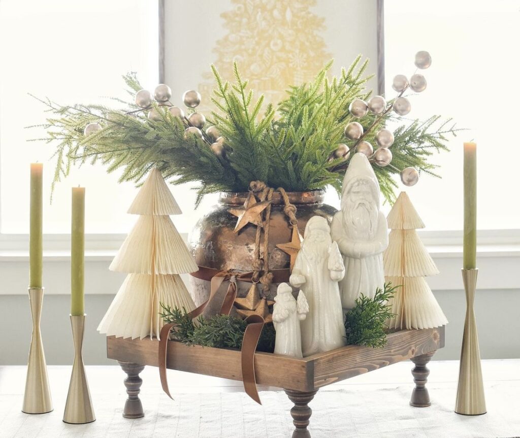 A Christmas centerpiece with a white Santa Claus and pine trees.