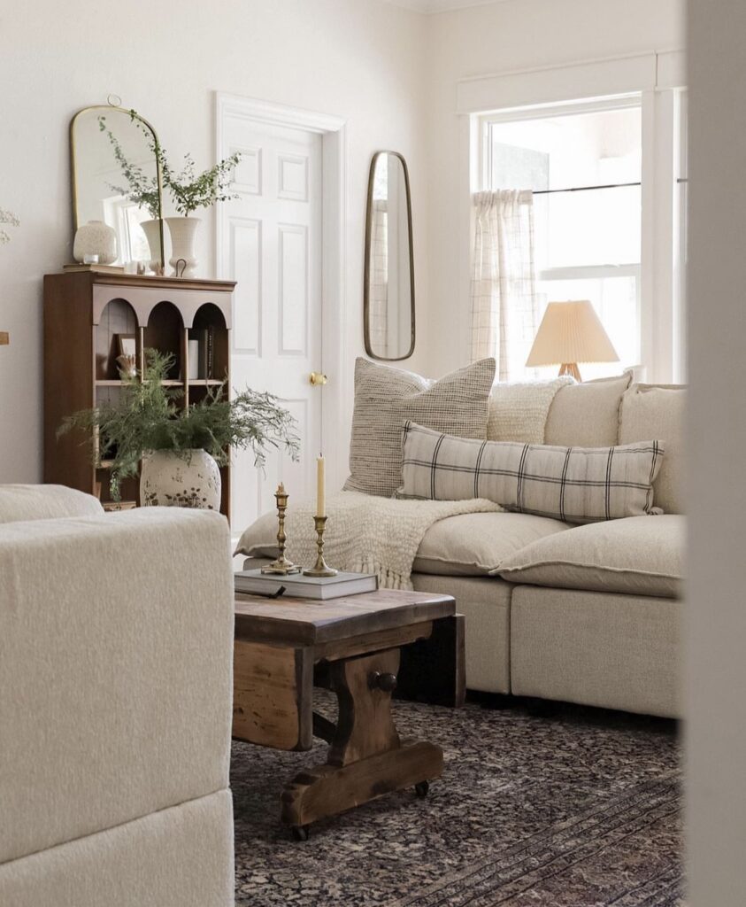 A cozy living room with an antique mirror.