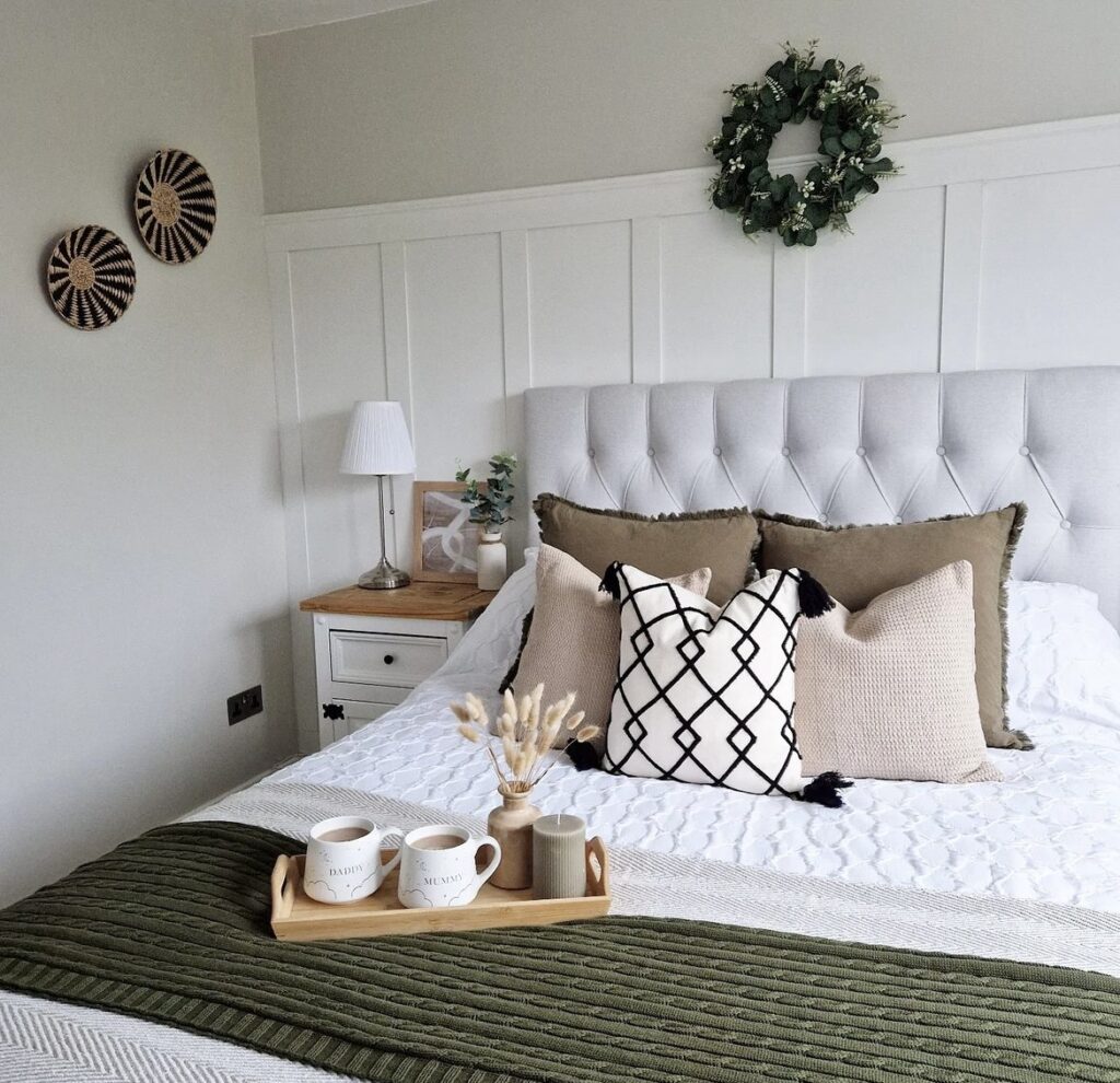 A green and white bedroom with light brown touches.