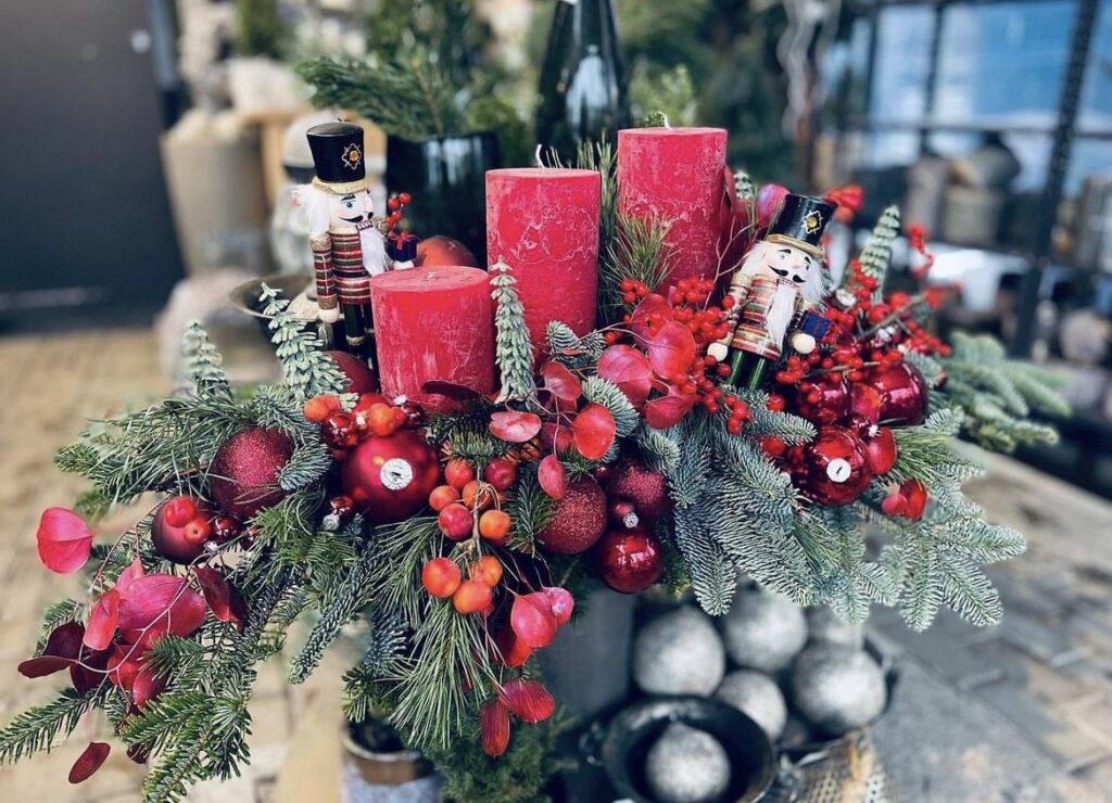 A Christmas centerpiece with red candles and nutcrackers.