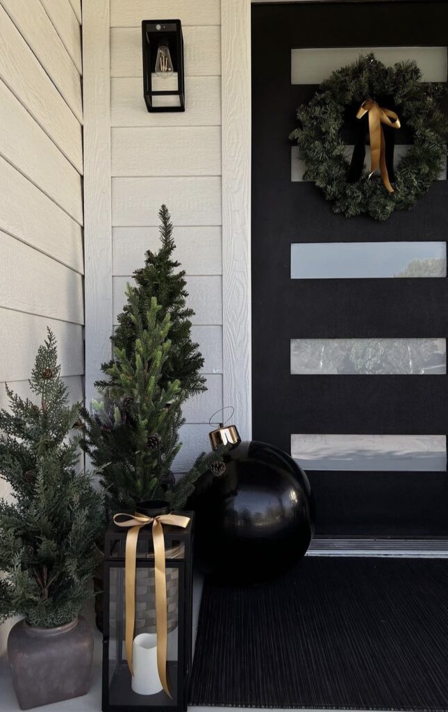 A Christmas porch with black and gold decorations.