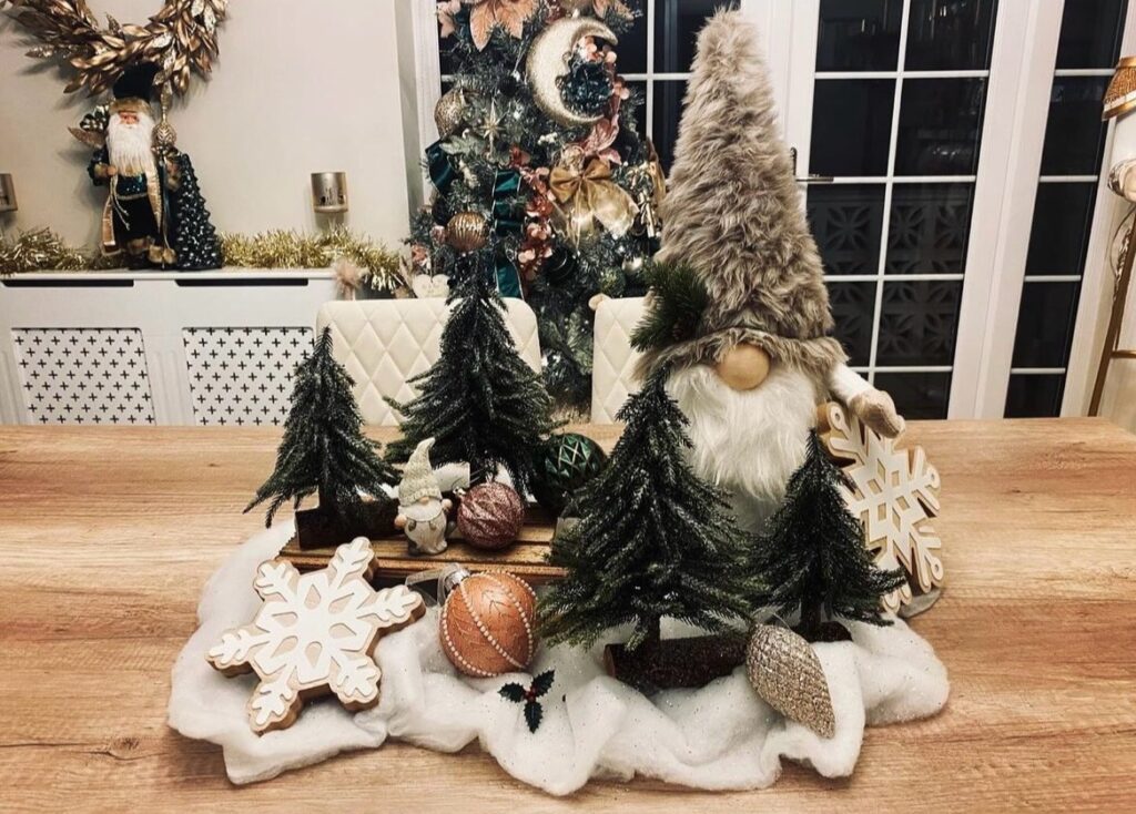 A Christmas centerpiece with gnomes and pine trees.