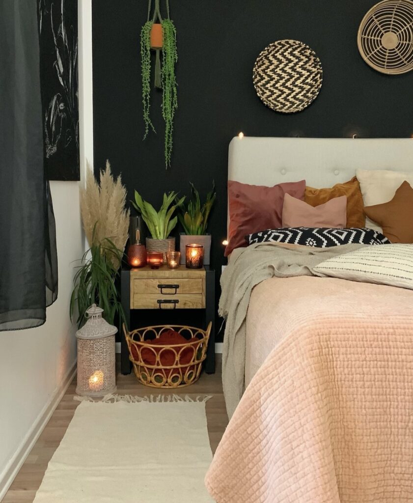 A bohemian bedroom with a black wall.