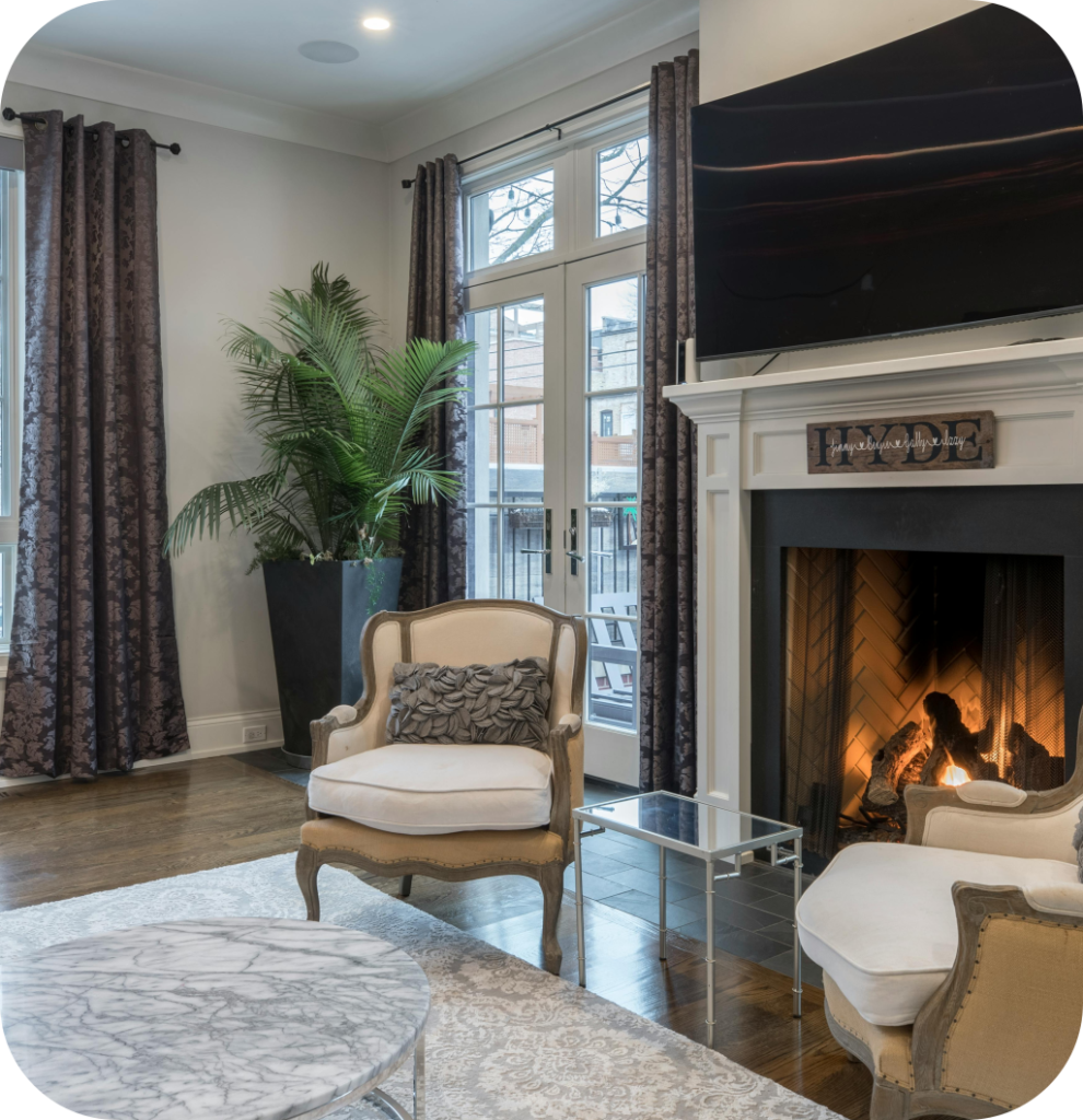 A cozy living room with an antique chair, an elegant rug and a fireplace.