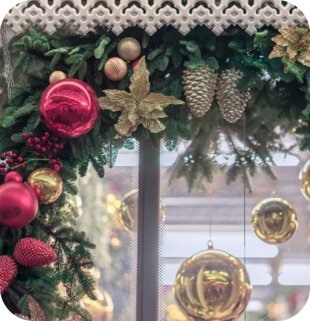 A pine branch garland with red Christmas balls, gold Christmas balls, gold flowers and pine cones.