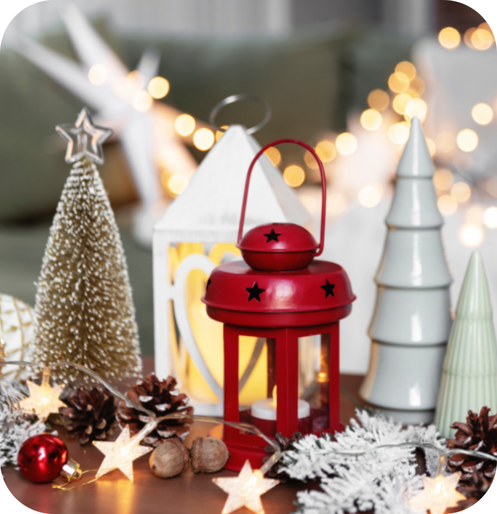 Mini pine trees with string lights, pine cones and a red candle lantern.