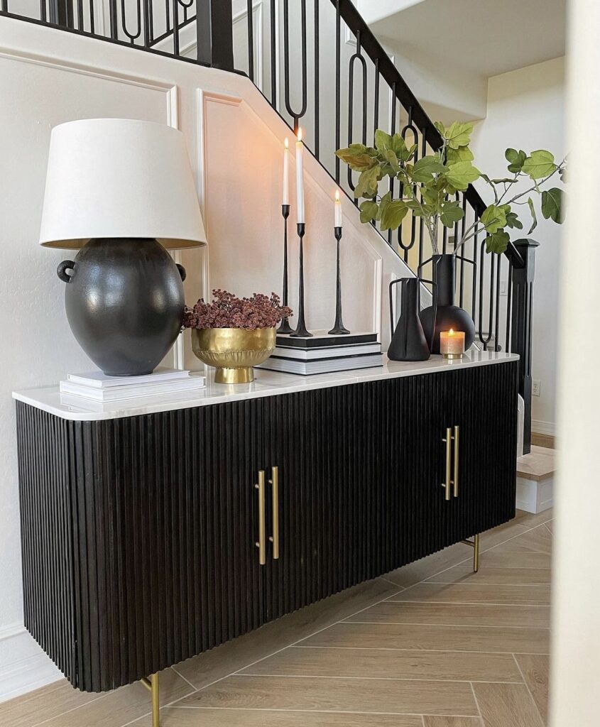 A black console table with a marble countertop.