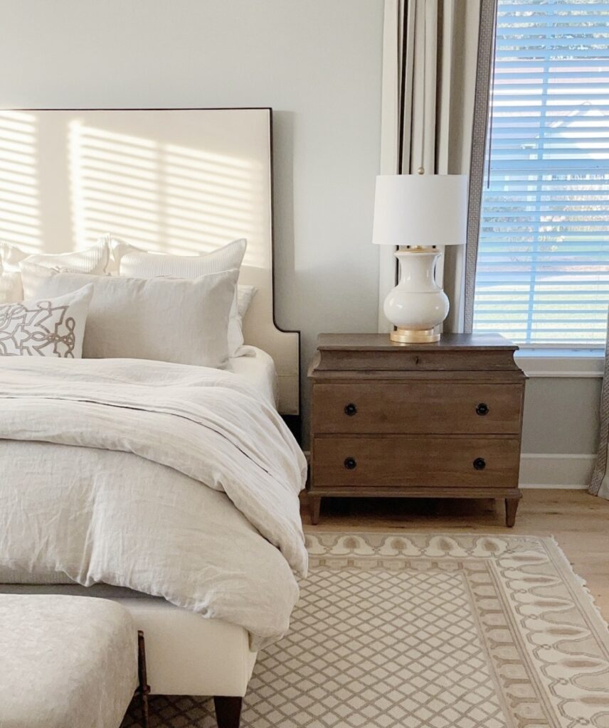 A neutral bedroom with wooden furniture.