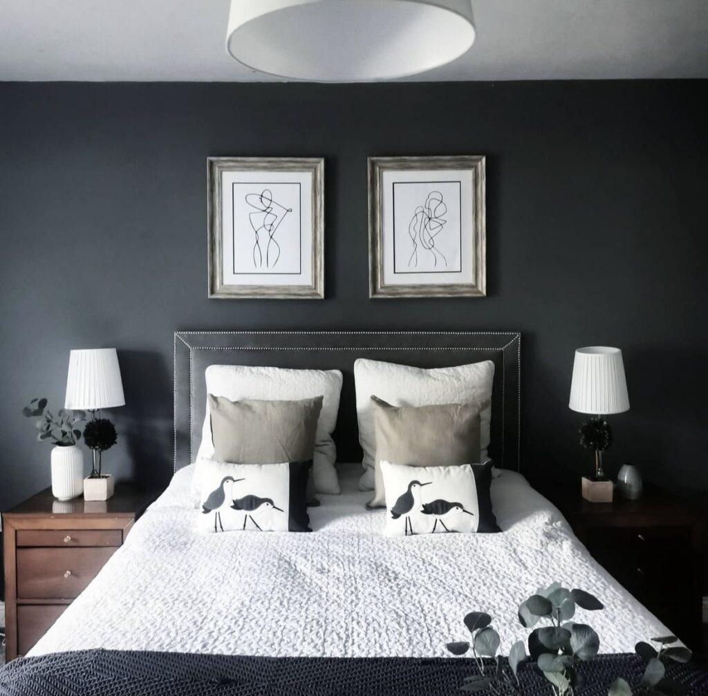 Minimalist prints in a black bedroom.