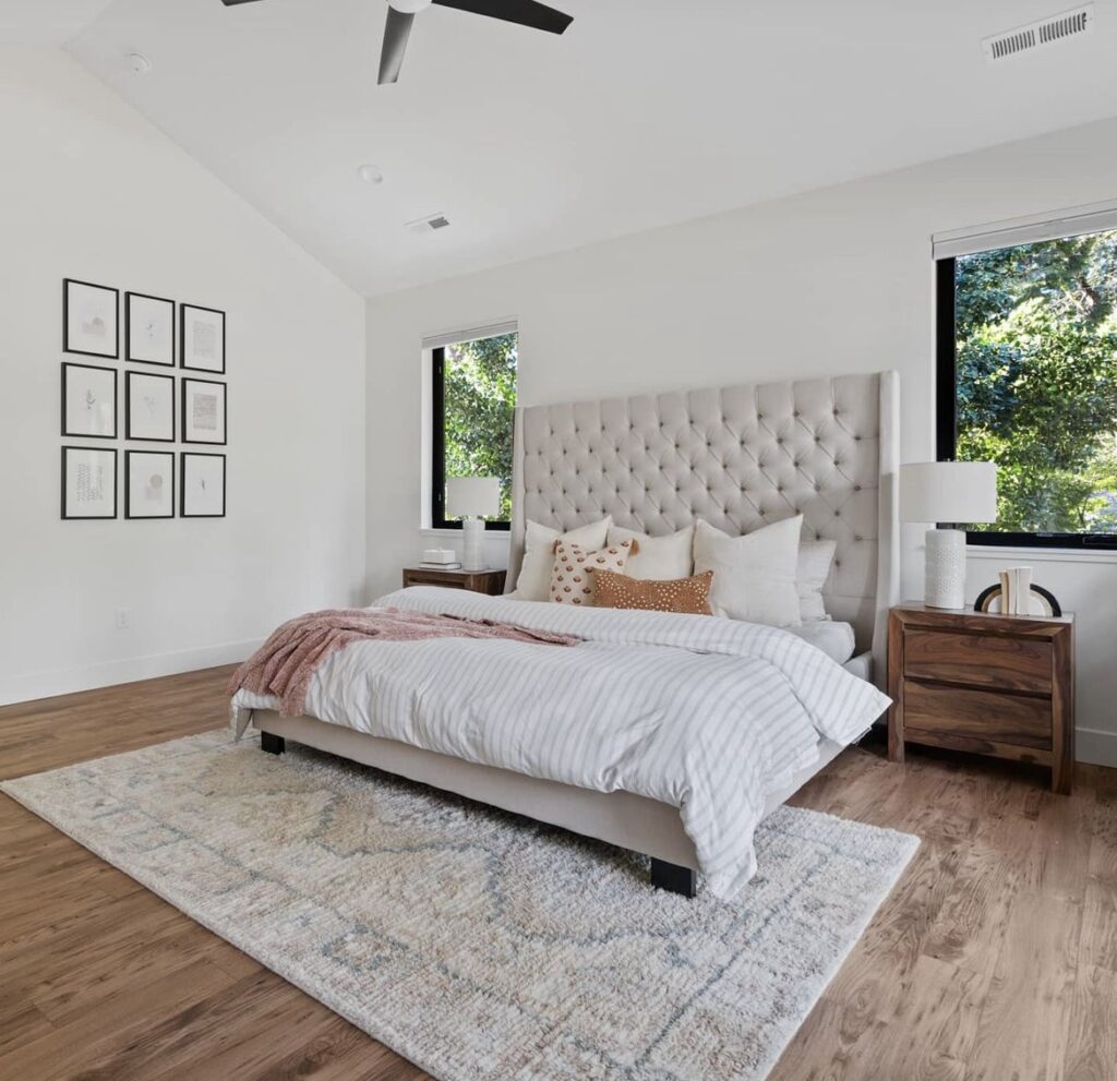 A neutral bedroom with a patterned rug.