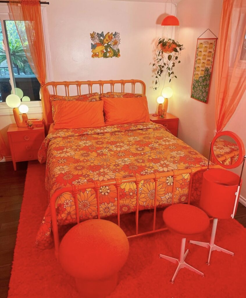 A colorful orange bedroom with retro furniture.