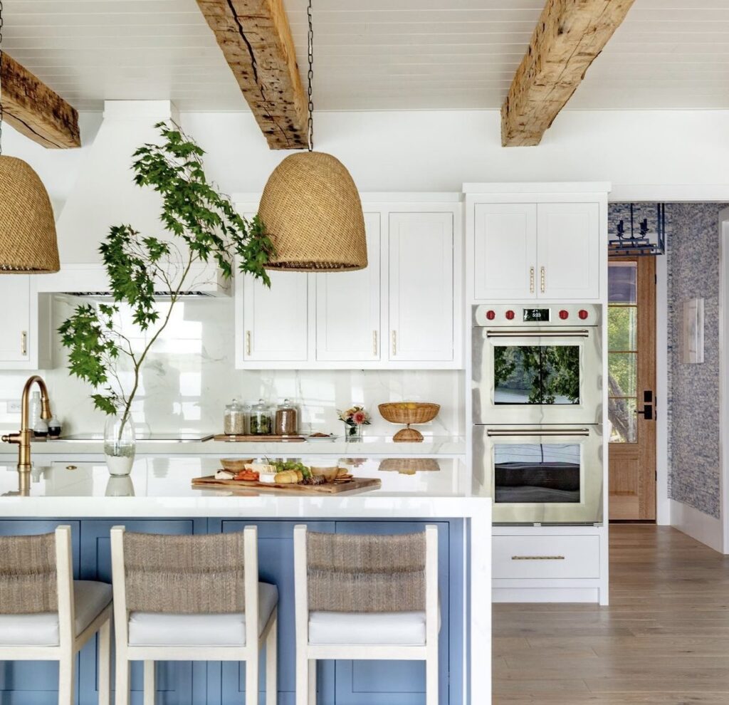 A blue kitchen island in a neutral kitchen.