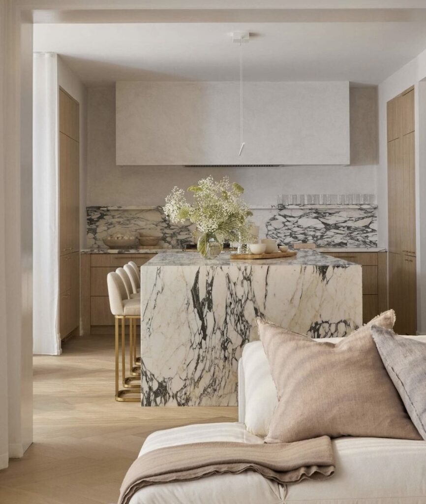 A marble island and backsplash in a kitchen.