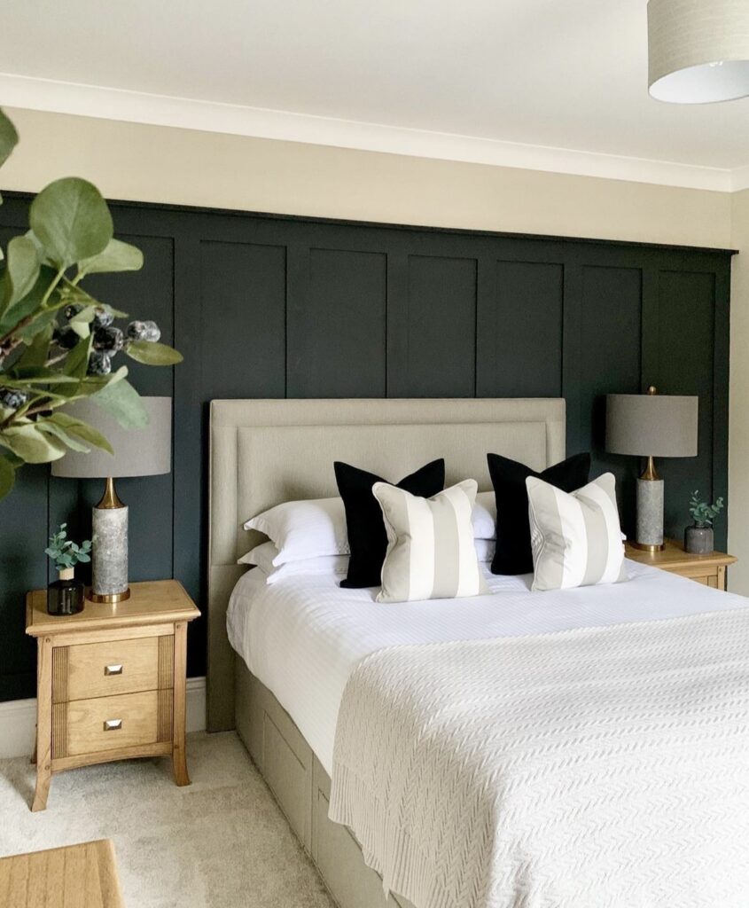 A forest green wall paneling with neutral decor.