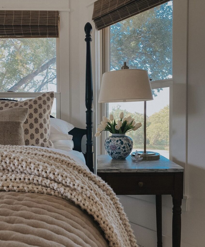 A wooden nightstand with a marble countertop in a traditional bedroom.