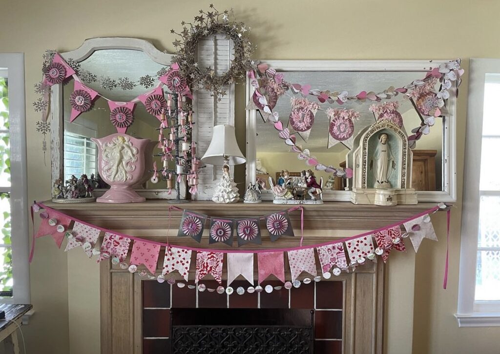 A mantel with Valentine garlands and vintage figurines.