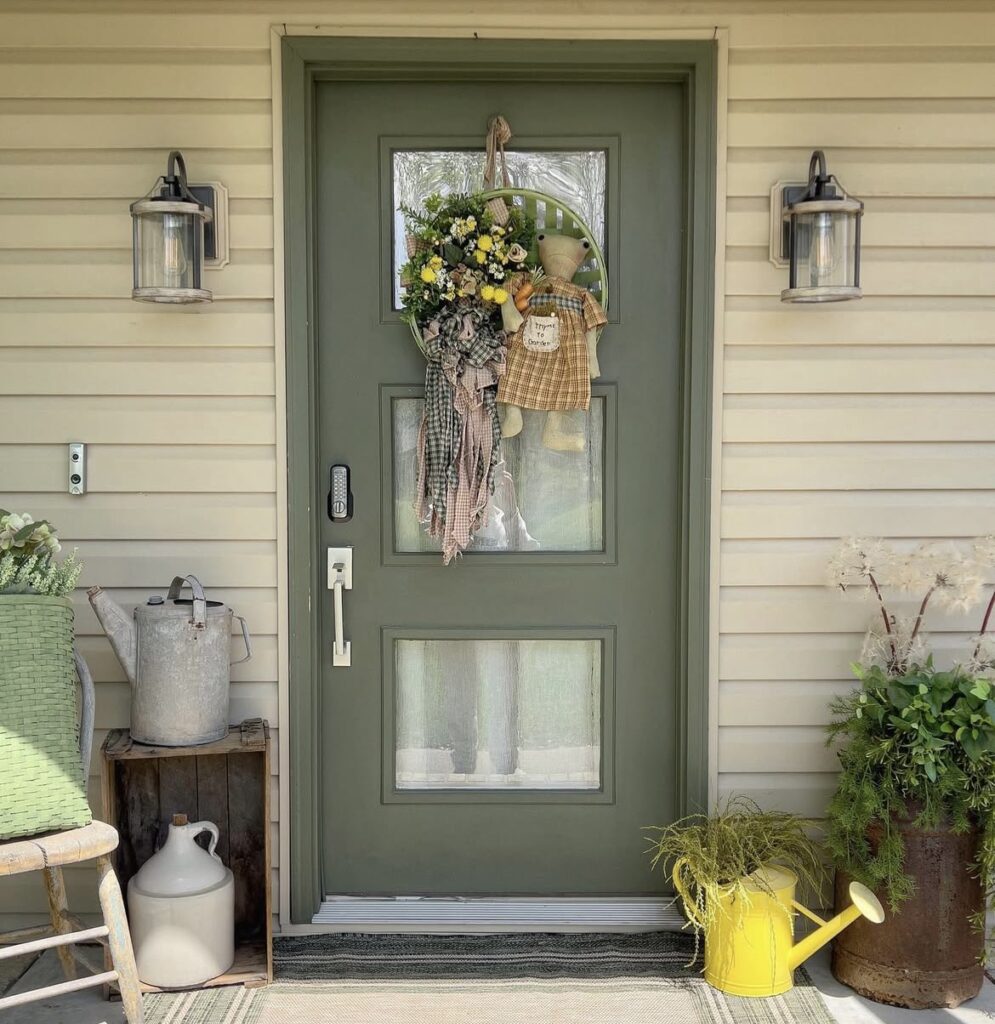 A frog wreath on a green front door.