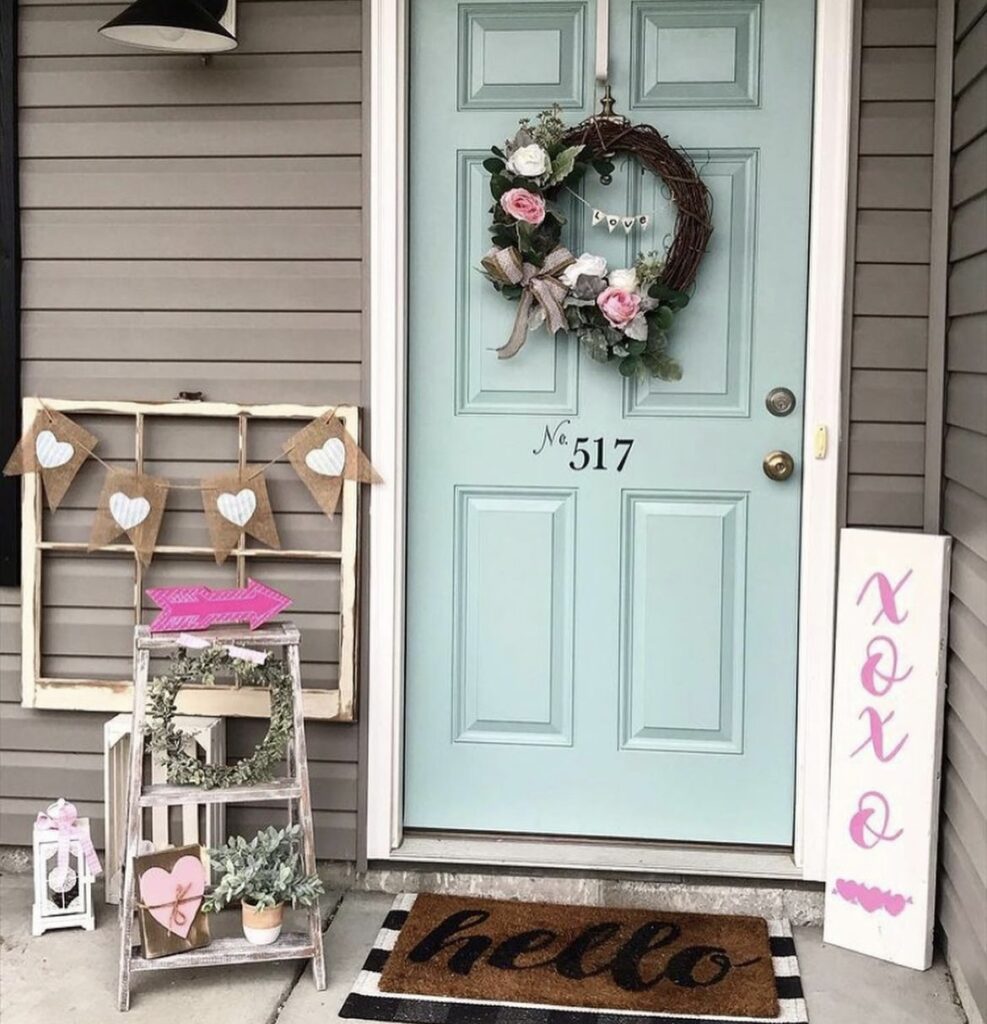 A front porch with a Valentine wreath and xoxo sign.