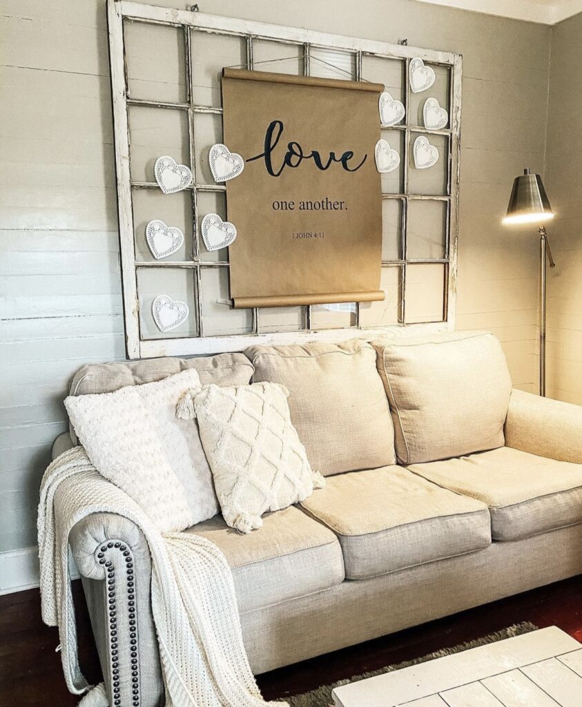 A love quote and garland above a sofa.