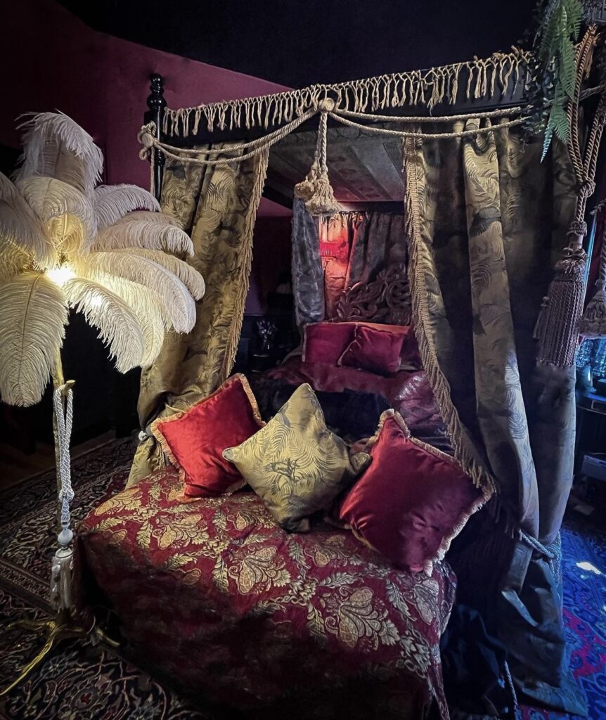 A dark academia bedroom with canopy bed curtains.