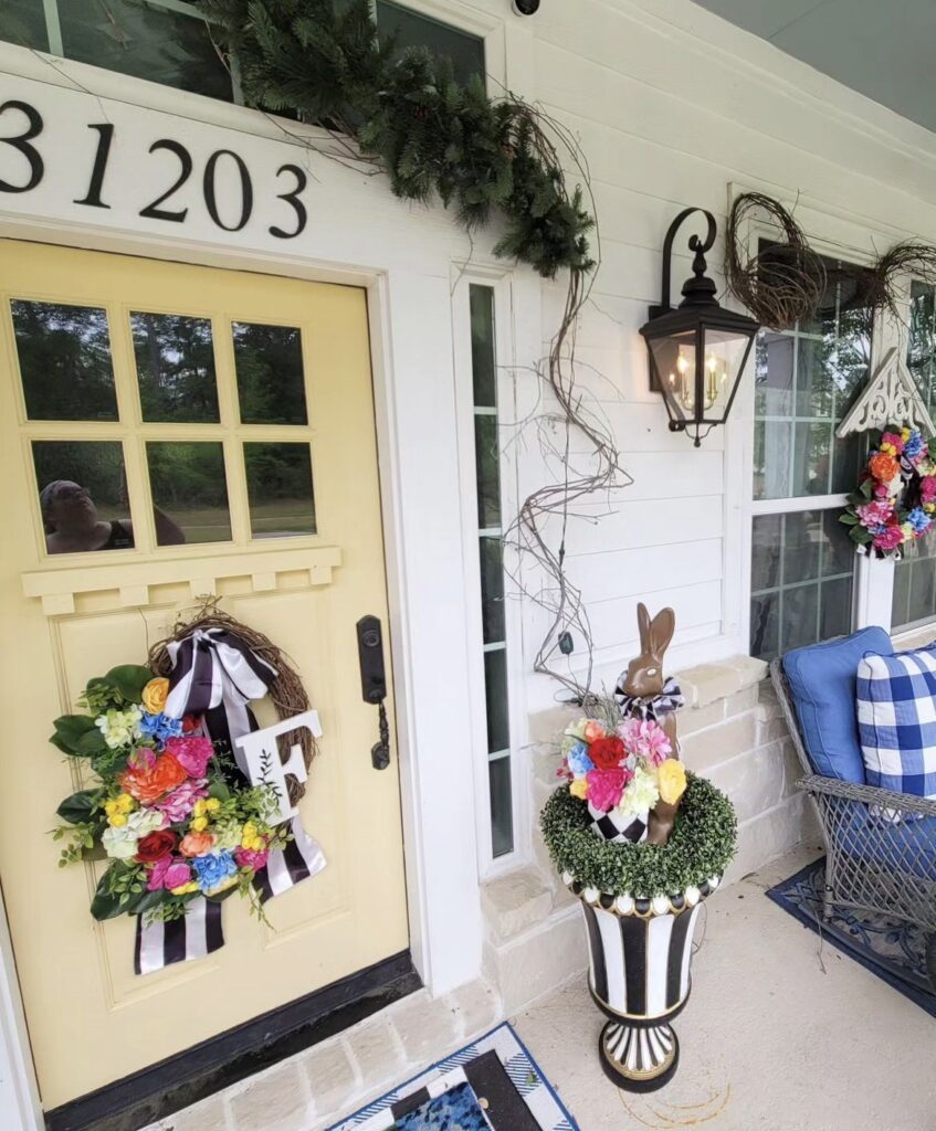 A colorful wreath on a yellow front door.