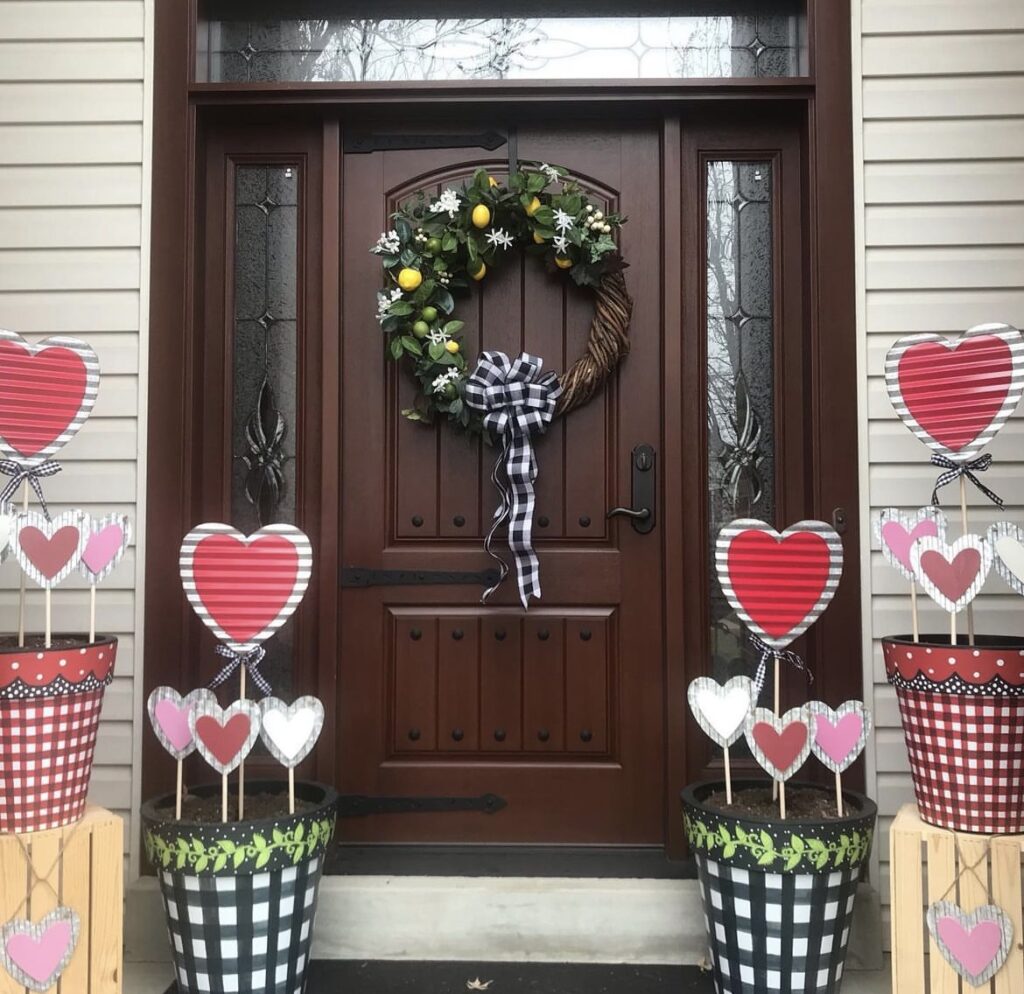 A front porch with heart signs in planters.