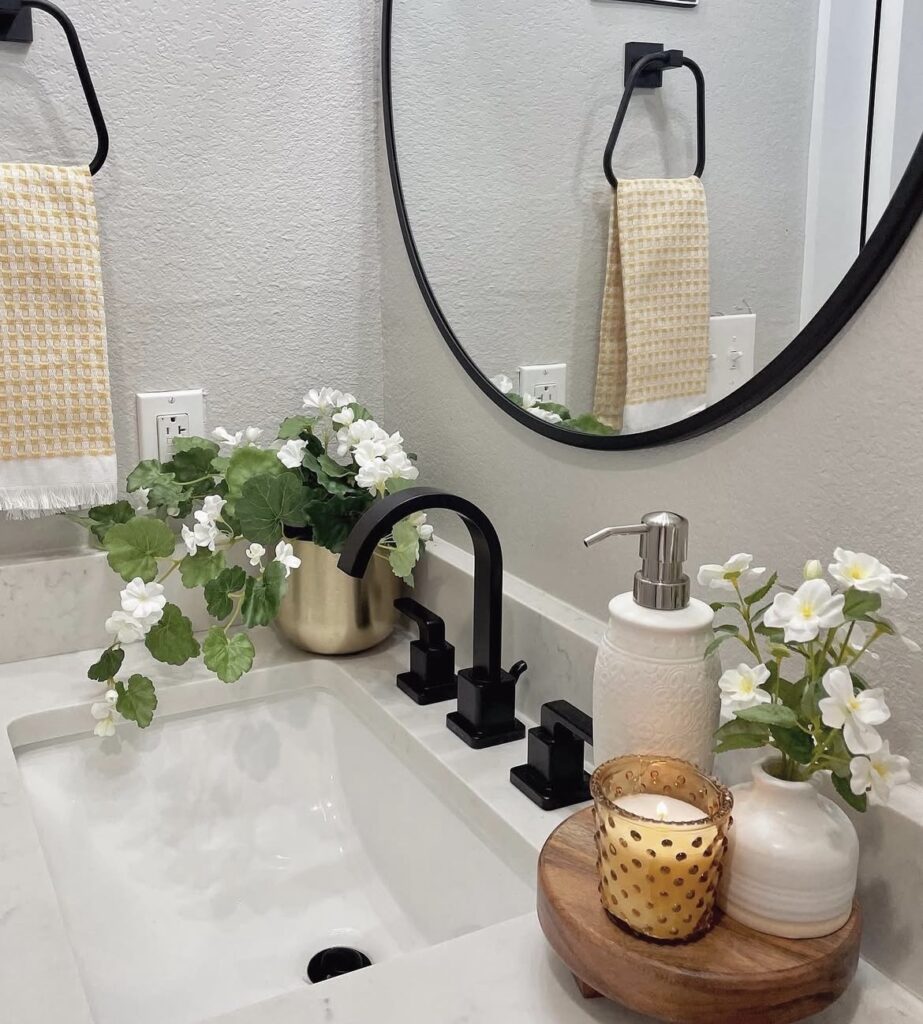 Fresh flowers with candles on a bathroom countertop.