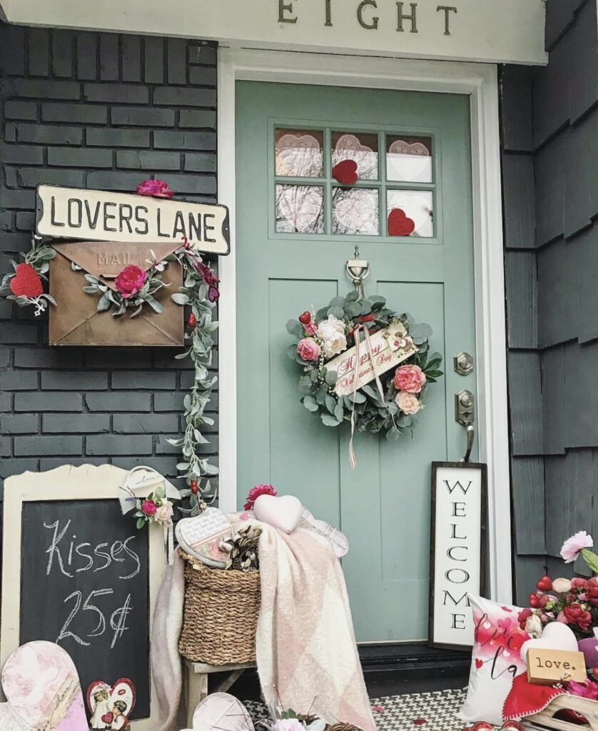 A front porch with a blue door and Valentine mailbox.