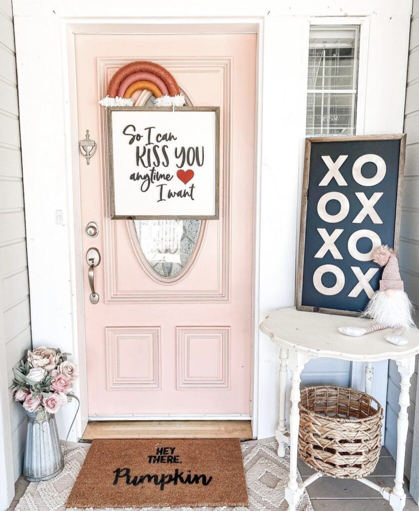 A front porch with a xoxo sign and flowers.