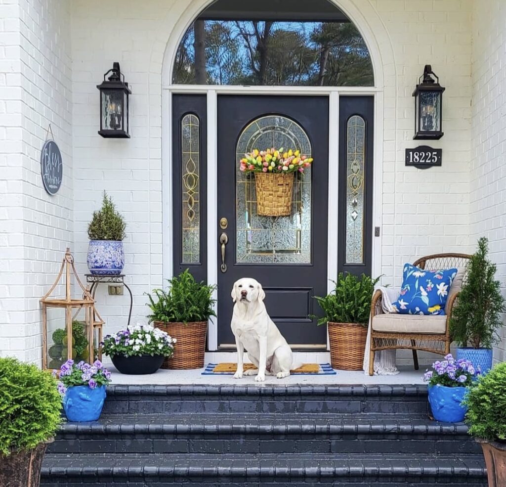 A woven basket filled with yellow flowers on a black front door.