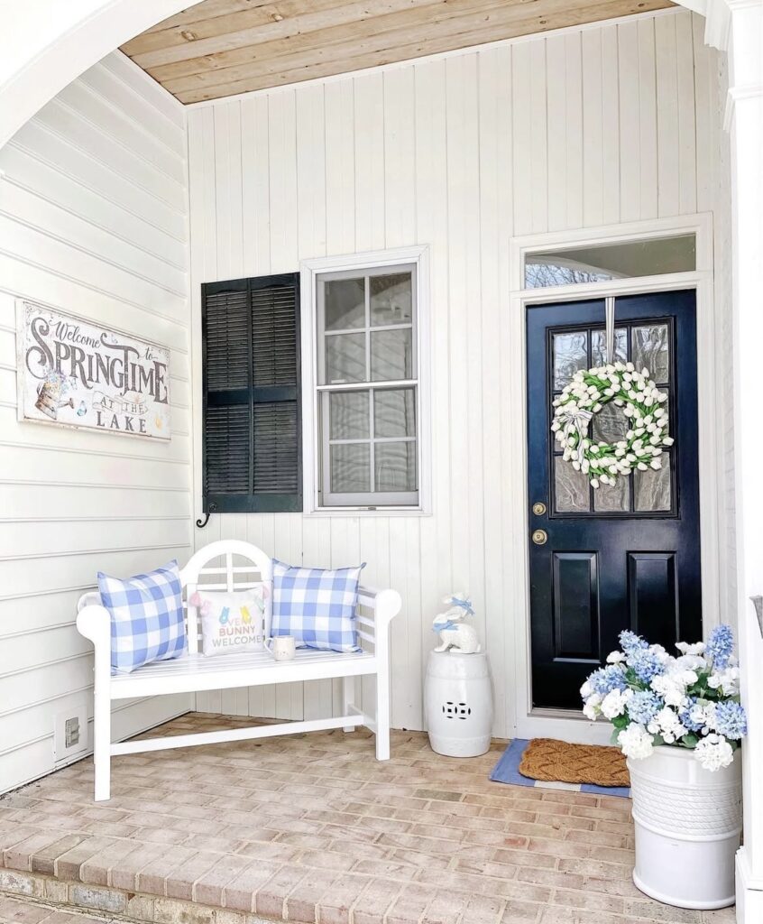 A white tulip wreath on a black front door.