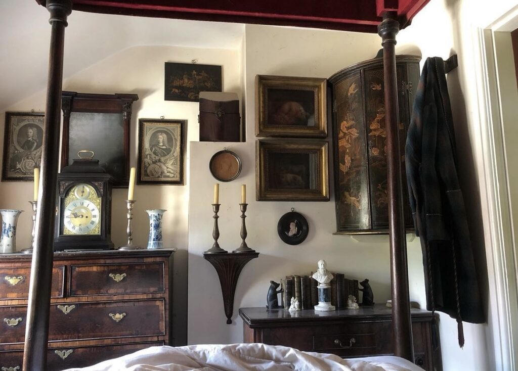 A bedroom with a vintage gallery wall.