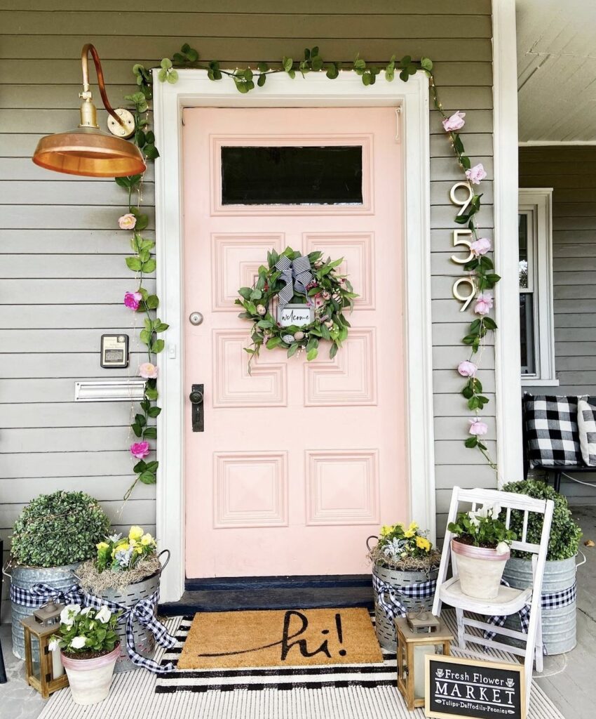 A floral garland and wreath on a pink front door.