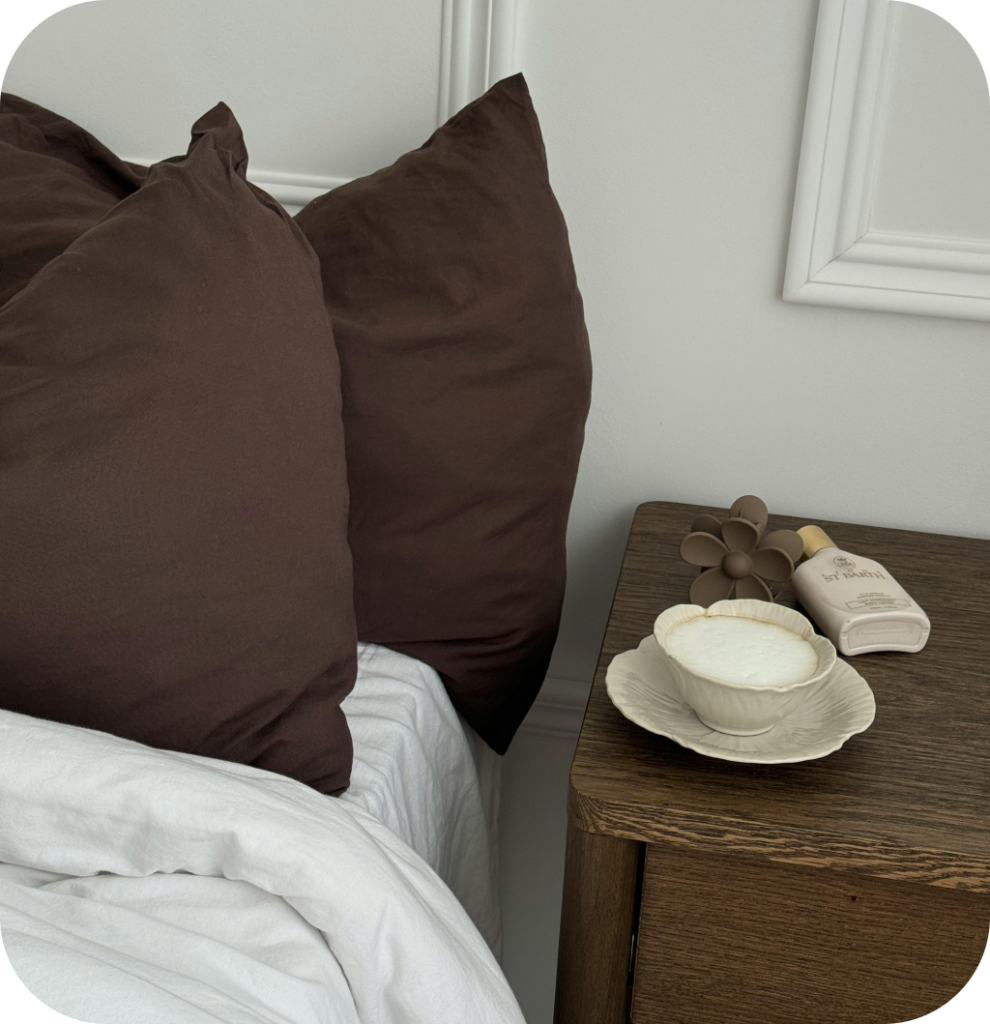 A bedroom with brown bedding and antique tableware.