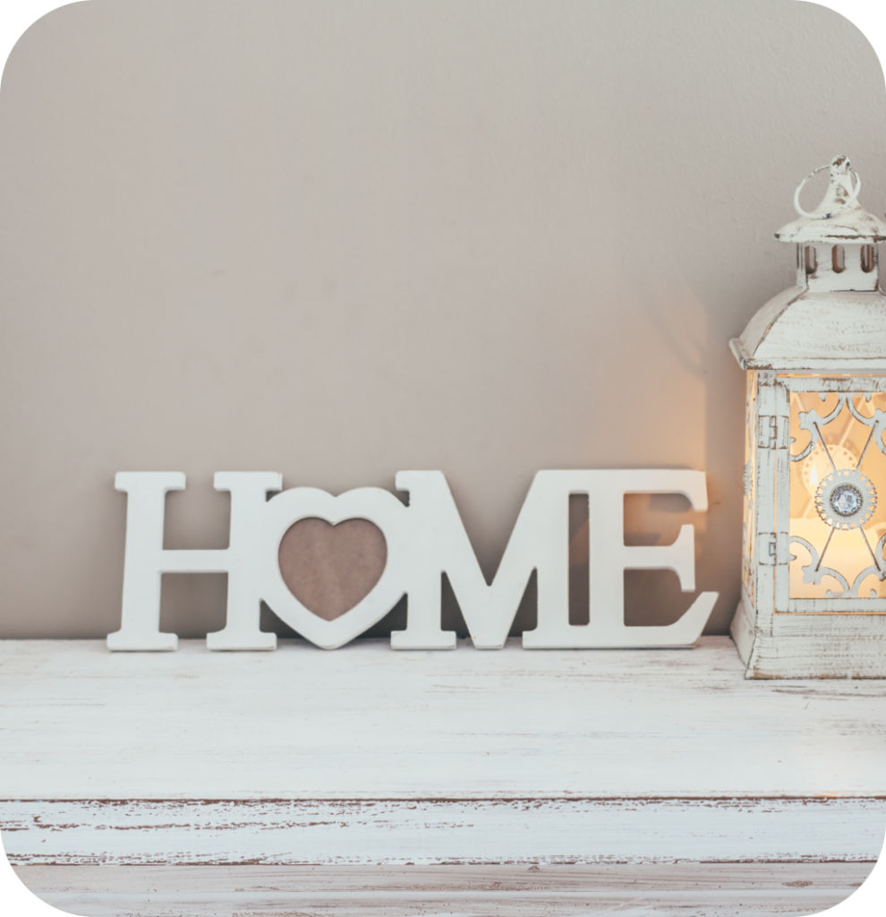 A home sign with a heart and a white distressed candle.