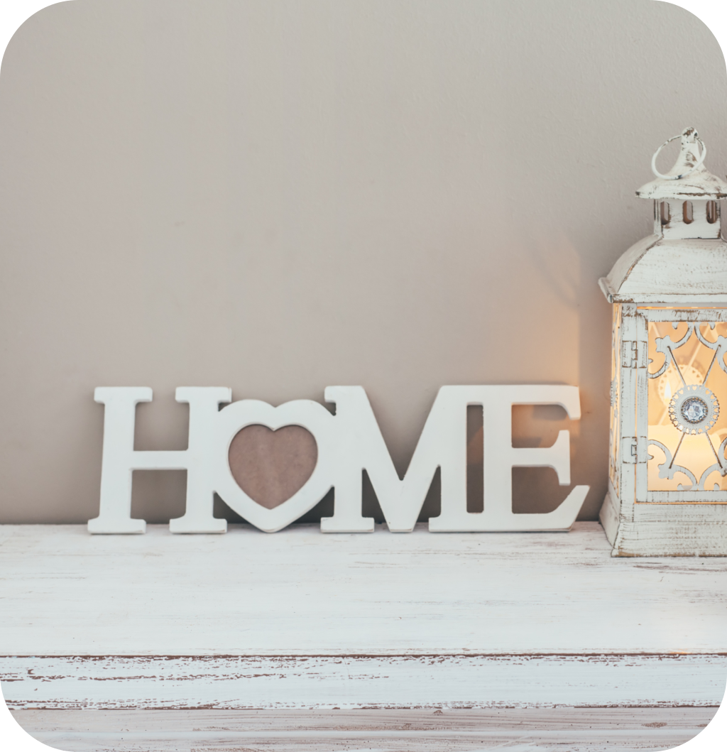A home sign with a heart and a white distressed candle.