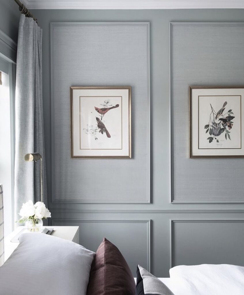 A bedroom with wall paneling.