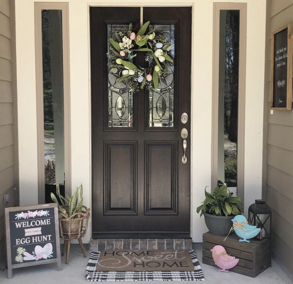 An Easter sign with bird cutouts on a front porch.