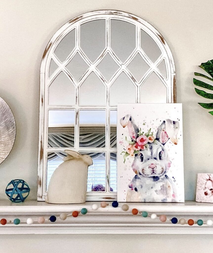 A rabbit painting on a mantel.